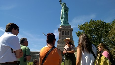 A ranger gives a tour on a bright summer day at the front of Liberty Island.