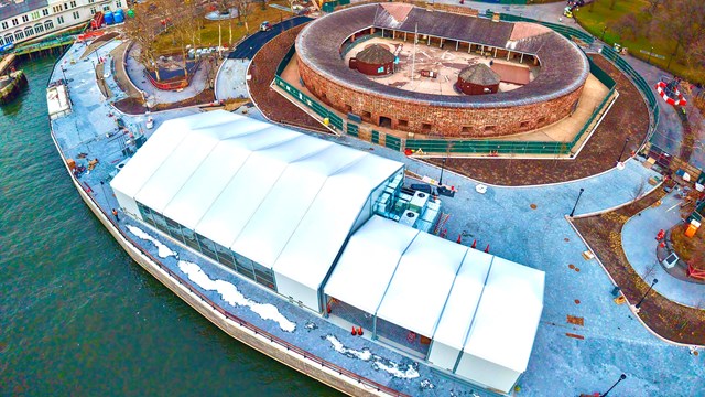 An aerial view of the white security building next to an oval structure.