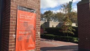 As visitors disembark the ferry, a sign reads 'Making your park better and safer.'