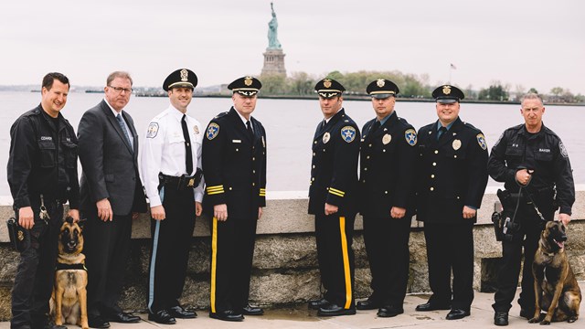 Park Police Officers and their K-9's on Ellis Island with the Statue in the background.