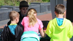 Kids visiting Liberty Island work on the Junior Ranger program with a park ranger.