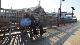 From the ferry dock on Liberty Island, a visitor in a wheelchair waits for the ferry.