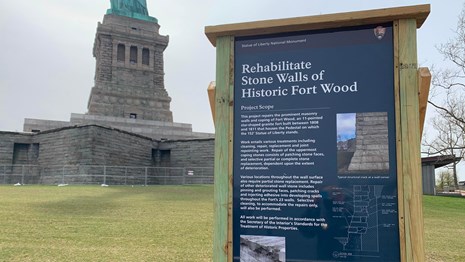 construction sign for fort in front of statue of liberty