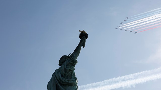 Military planes fly in formation above the Statue of Liberty.