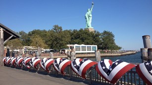 A view of New York Harbor with Liberty Island and the statue in the foreground.