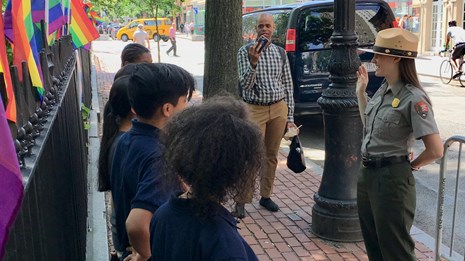 Park ranger gives the junior ranger oath to a group of young visitors 