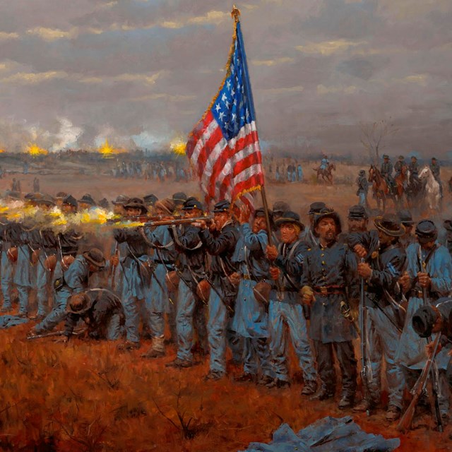 Union soldiers stand and fire next to an American flag. Moving troops and firing cannons behind.