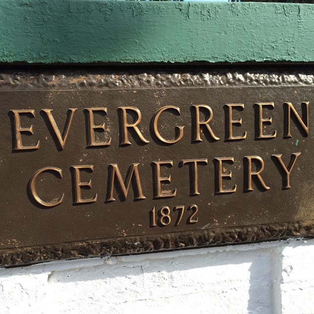 A bronze or brass plaque reads 