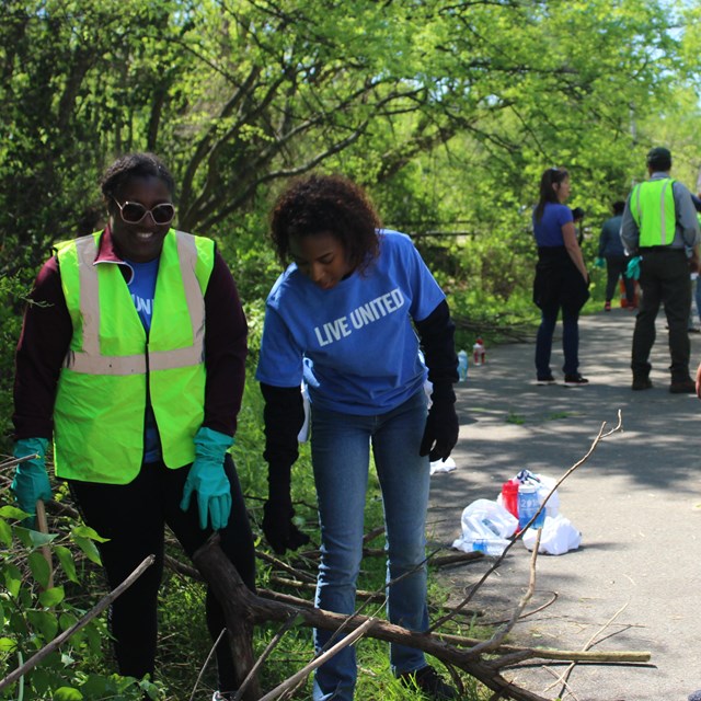 A group of volunteers with gloves and tools working outside