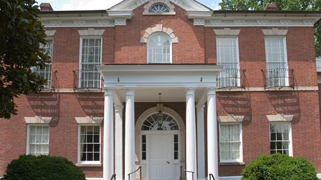 A two-story brick structure with a covered entrance.