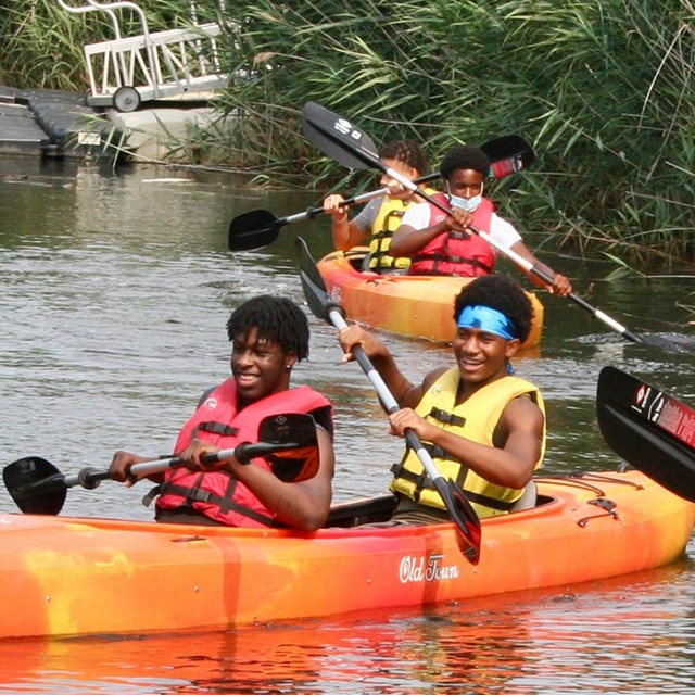 People kayaking near wetlands