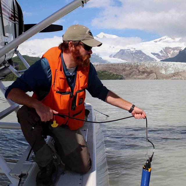 A researcher collects a water sample.