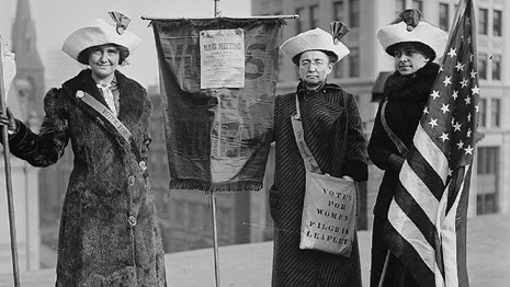 Photo of women holding flag.