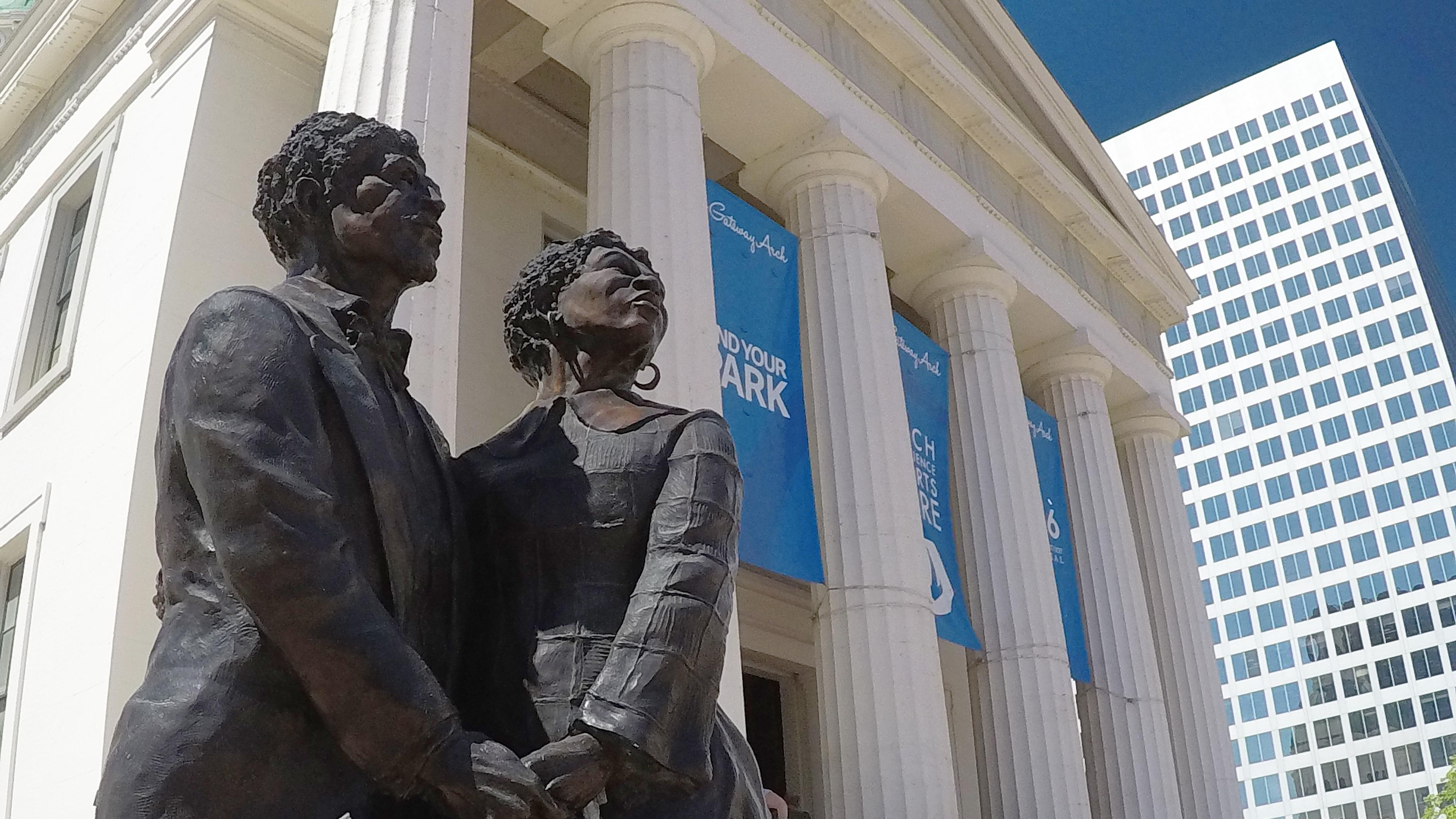 Photo of a statue of two people in front of Old Courthouse. 