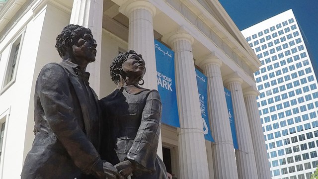 Photo of a statue of two people in front of Old Courthouse. 