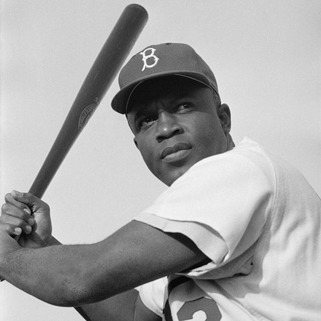 Jackie Robinson holding a bat, ready to swing. 
