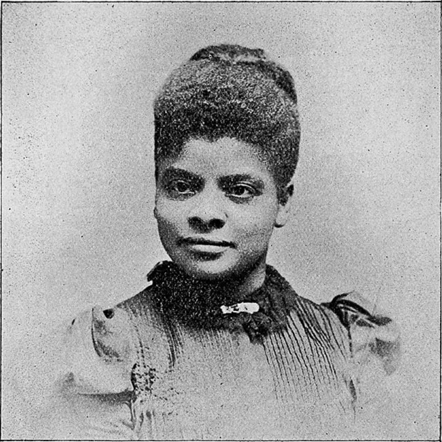 African American woman wearing dress with high collar and bun