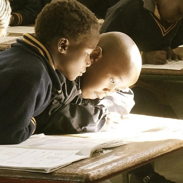 Children looking at a book. 