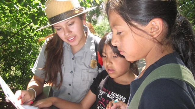 NPS ranger holds paper instructing students. 