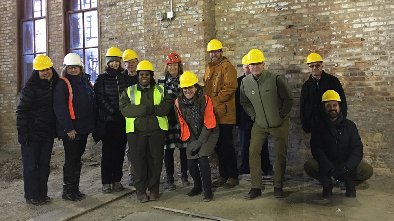 A group of people wearing yellow hard hats