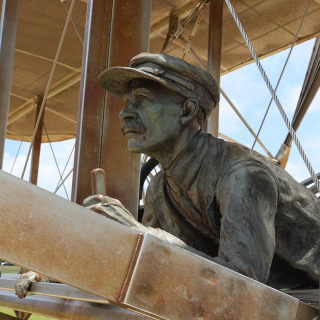 Sculpture of Orville Wright in the flyer. NPS Photo