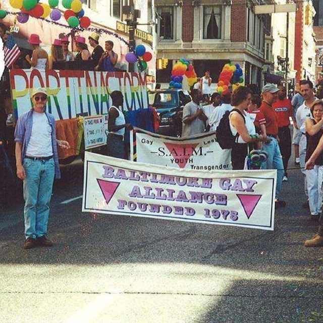 People holding a banner reading Baltimore Gay Alliance