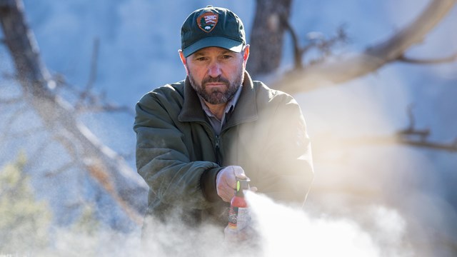 A bear biologist deploys bear spray during a demonstration.