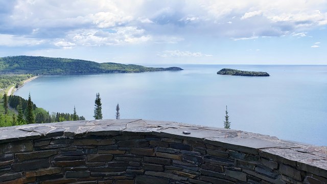 A stone restraining wall in front of a view of a bay.