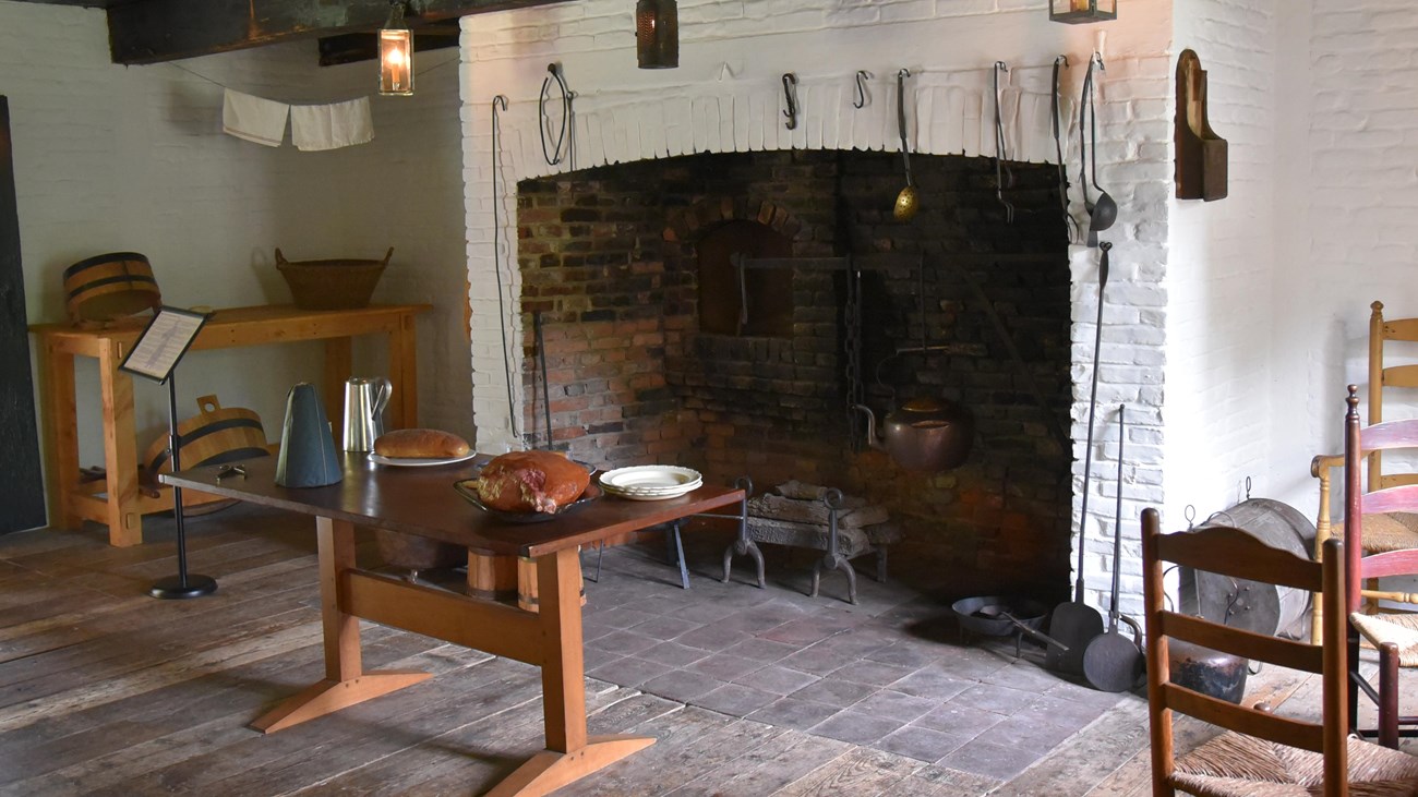 A large fireplace. A table sits in front of the fireplace, surrounded by tools and accessories.