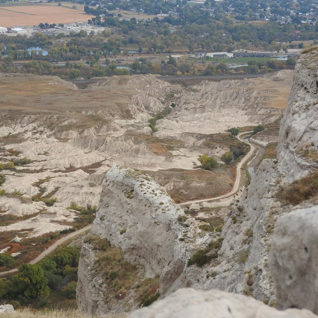 Badland formations are seen from a high vantage point above. 