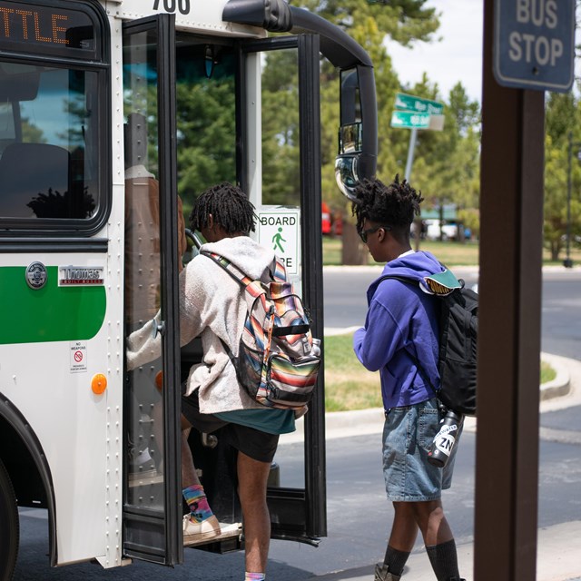 Two visitors board a park shuttle bus.