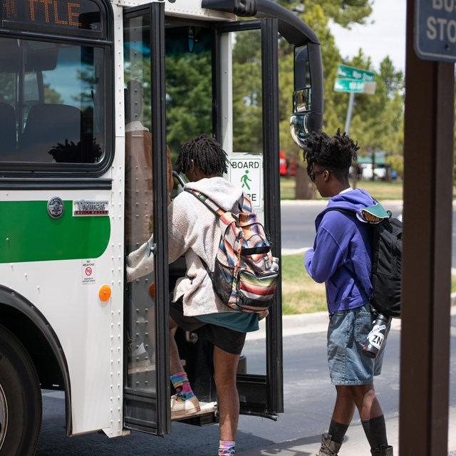 Two visitors board a park shuttle bus.