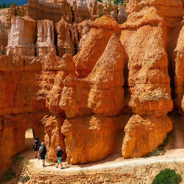 Hikers approach an archway on a hike