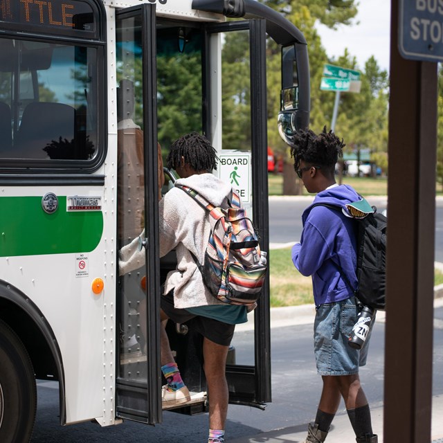 Two visitors board a park shuttle bus.