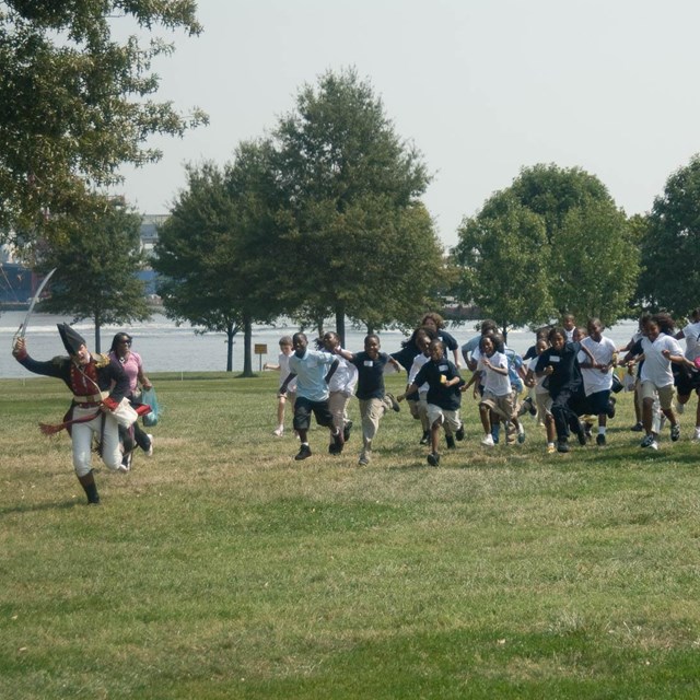 A living historian leads a school group in a school program.