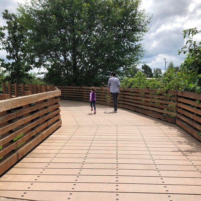 A man and child walk on a trail.
