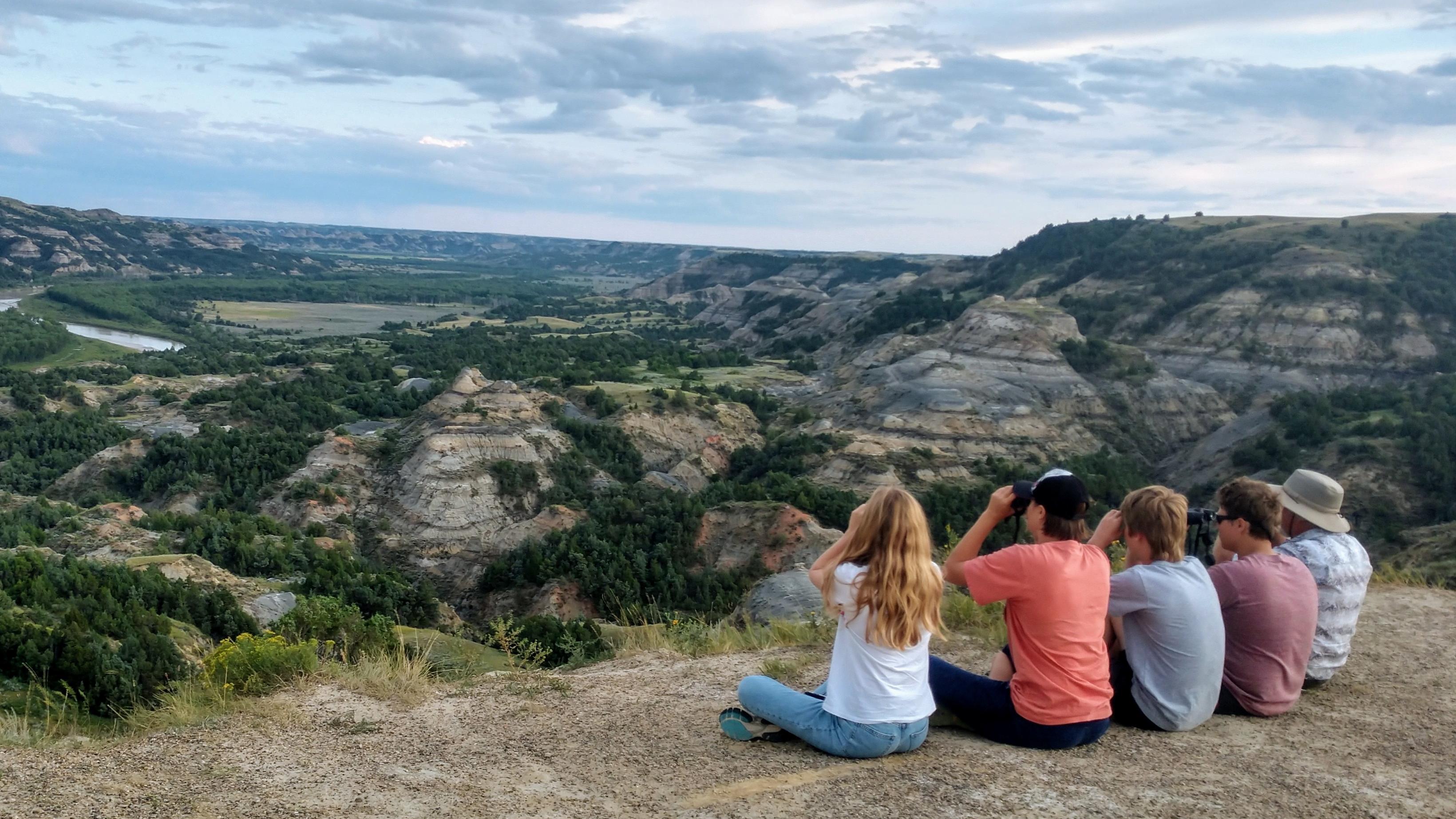 5 people look through binoculars. 