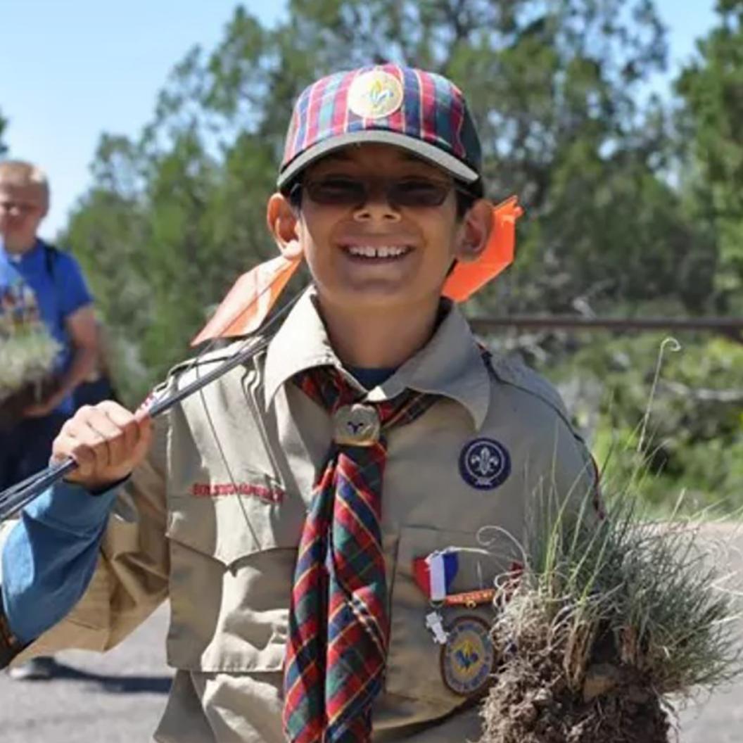 A boy smiling in boy scout uniform.