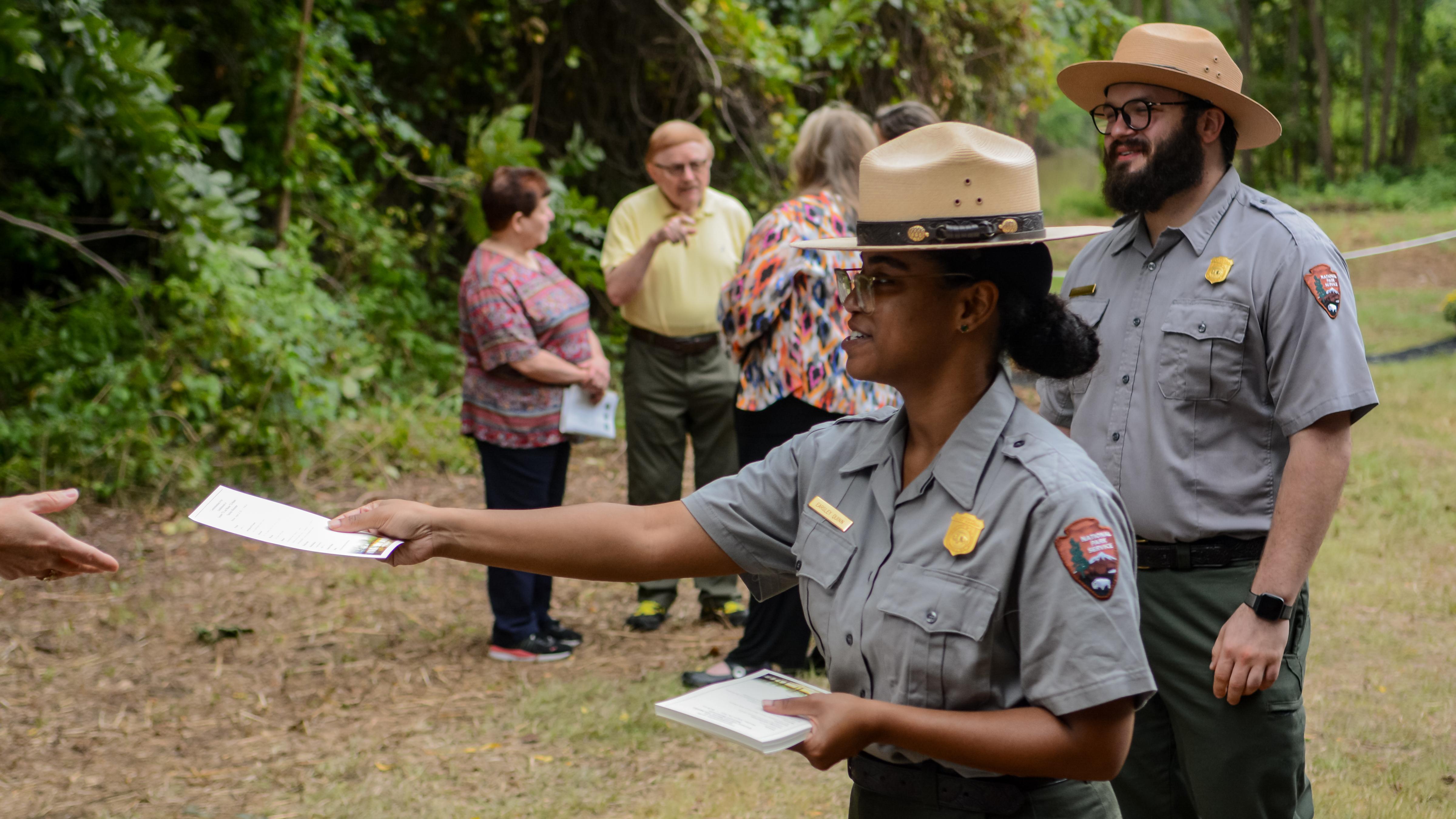 Rangers hands a brochure to a visitor