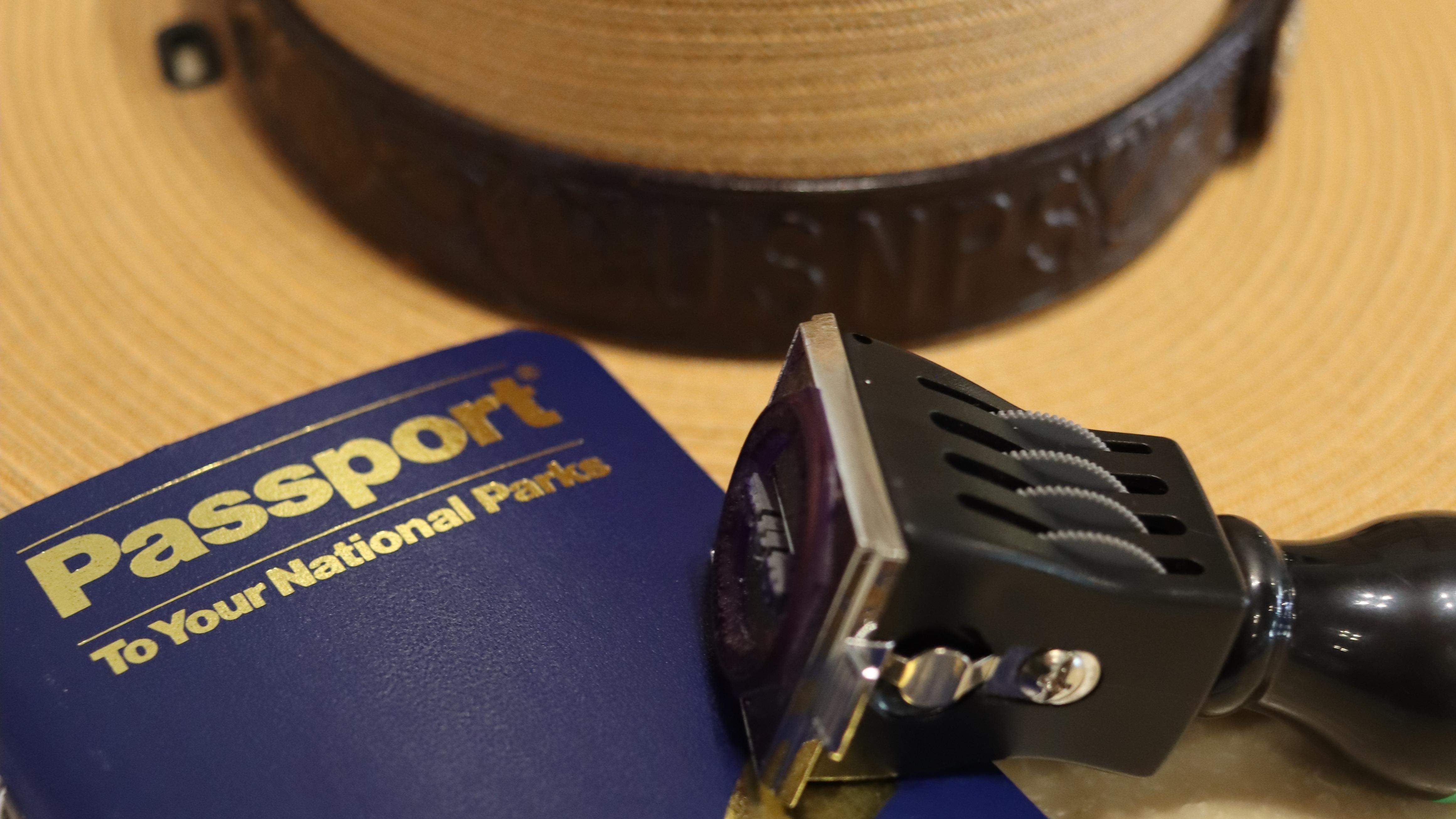 passport book and passport stamp resting on a ranger hat