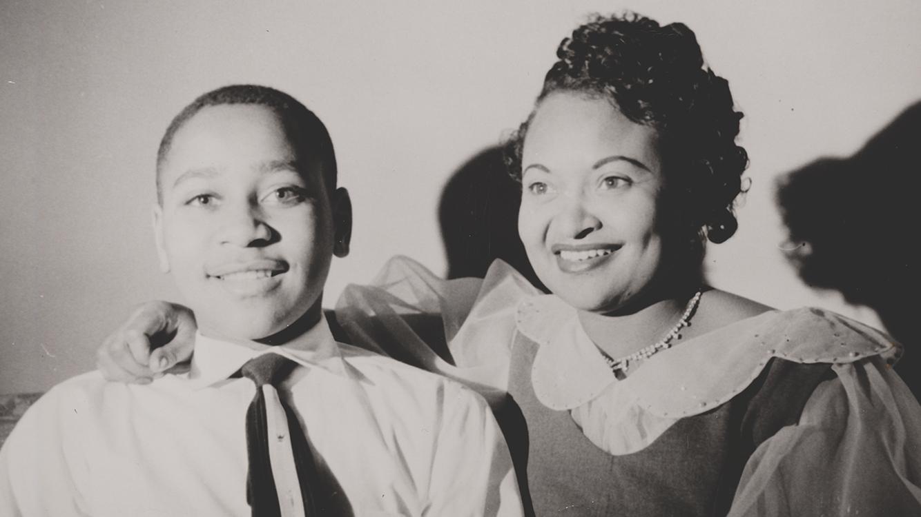 A portrait of a young man and adult woman, smiling.