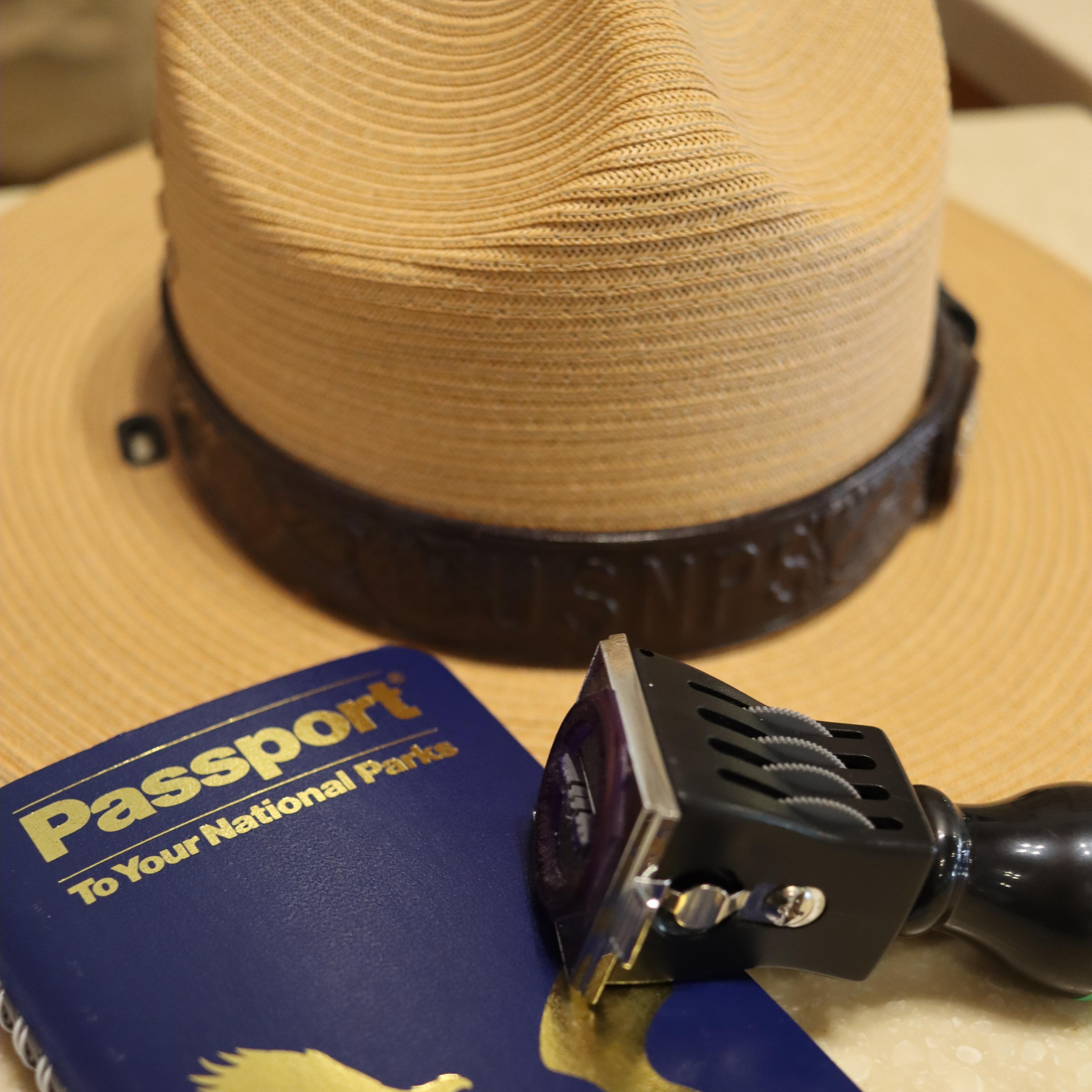 passport book and passport stamp resting on a ranger hat