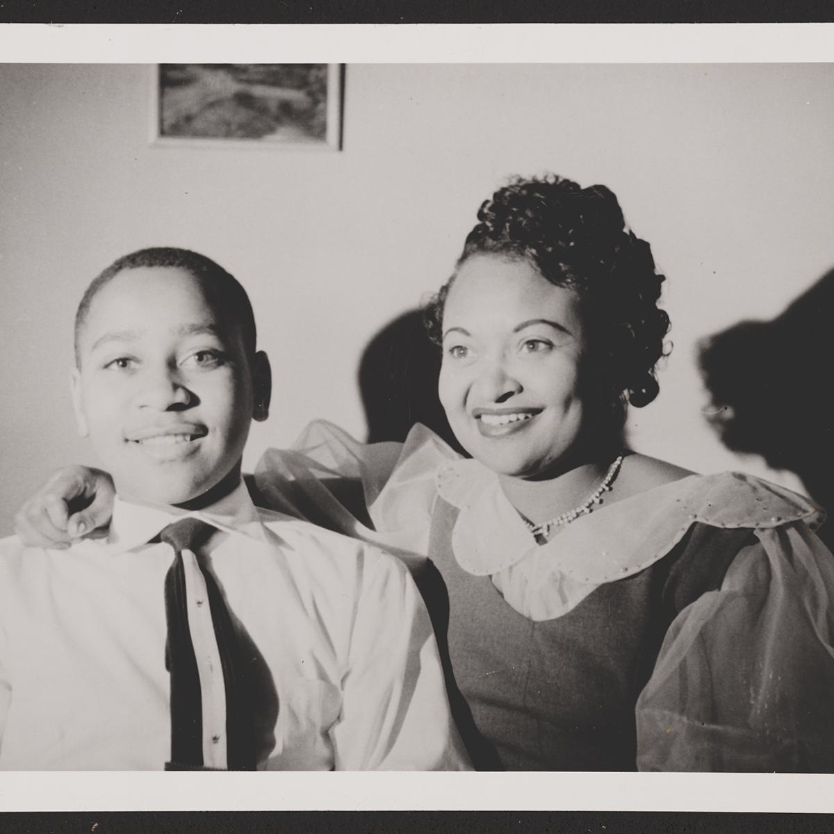 A portrait of a young man and adult woman, smiling.