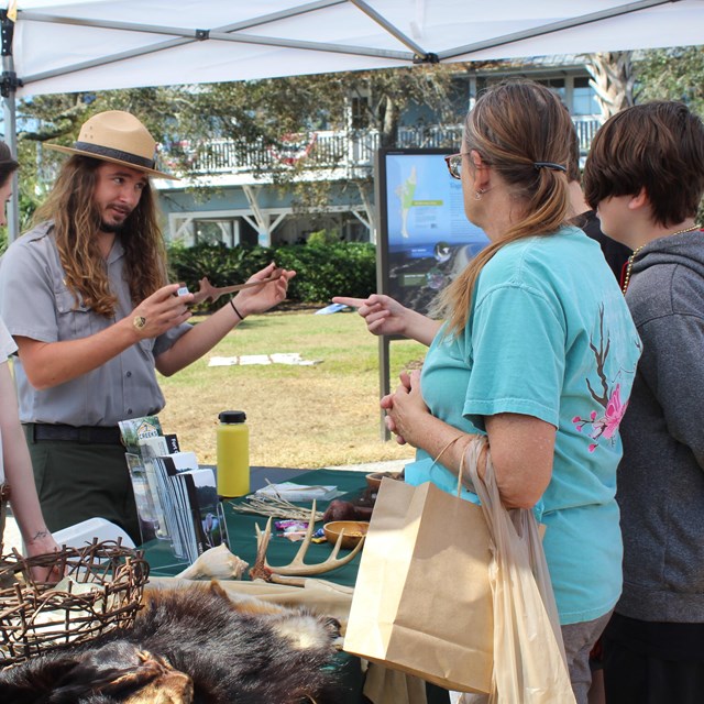 ranger at table talks to 3 visitors 