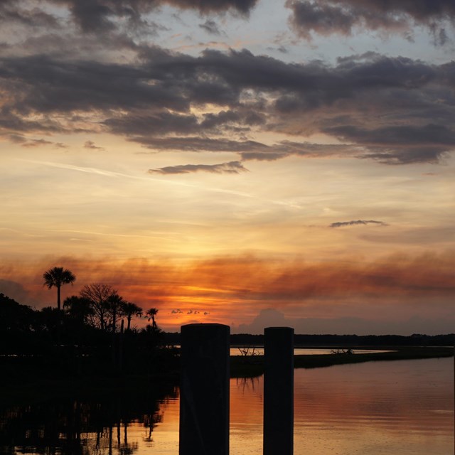red and smoke on the horizon seen from across the water 
