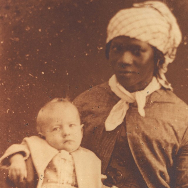 enslaved woman holding owner's child 
