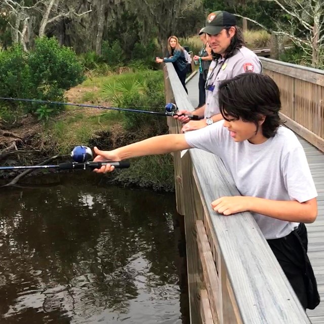 Ranger and kid fishing from dock 