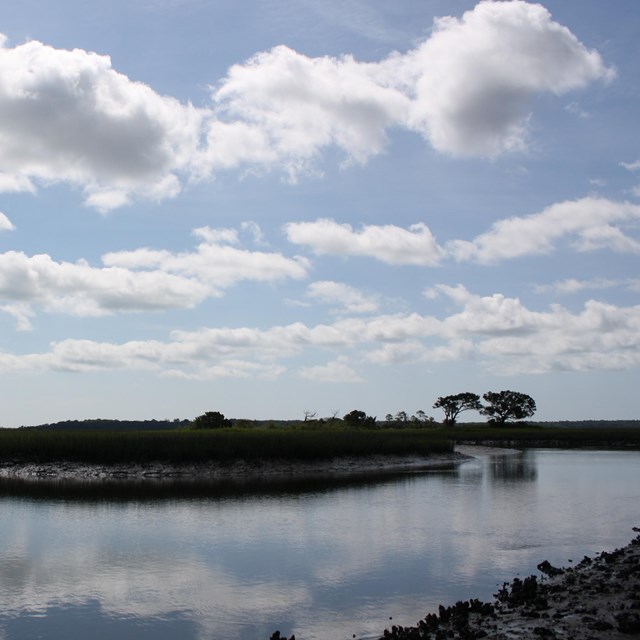 horseshoe bend in creek with clouds above