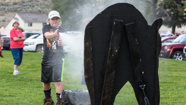 kid uses bear spray on a bear cutout