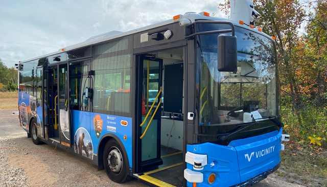 A bus is parked at the edge of a paved road